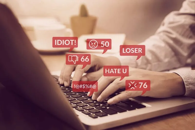 Person wird am PC mit Hasskommentaren gemobbt