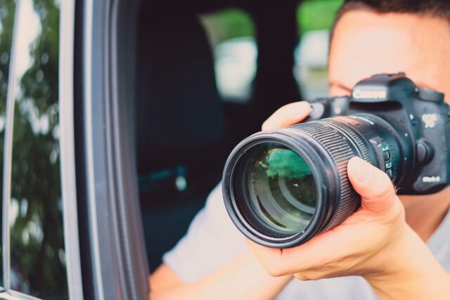 Privatdetektiv der Detektei für Brohltal fotografiert mit Kamera aus Autofenster, professionelle Observation durch Ermittler.