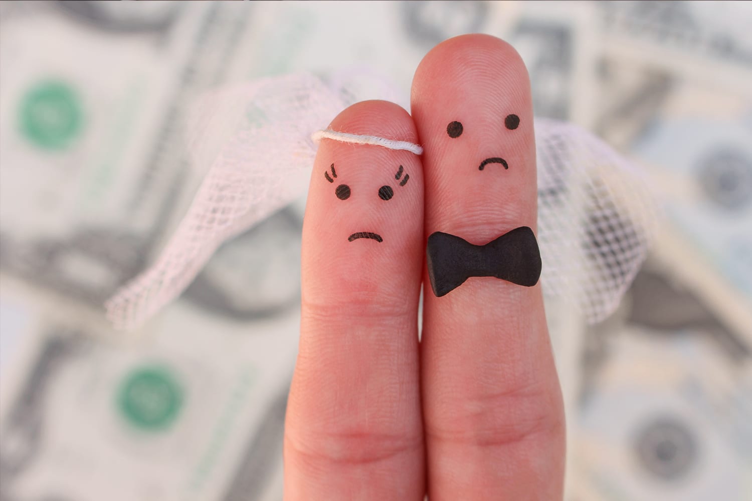 2 Finger die eine Braut und einen Bräutigam darstellen, Im Hintergrund verlorenes Geld durch einen Heiratsschwindler