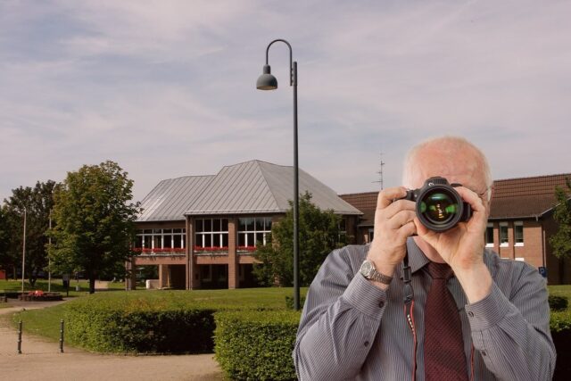 Schriftzug: Detektei Kubon ermittelt in Hürtgenwald, Detektiv der Detektei fotografiert. Rathaus in Hürtgenwald