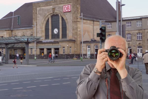 Der Hauptbahnhof in Mönchengladbach, Detektiv zeigt Daumen nach oben, Schriftzug: Unserer Detektei ermittelt für Sie in Mönchengladbach !
