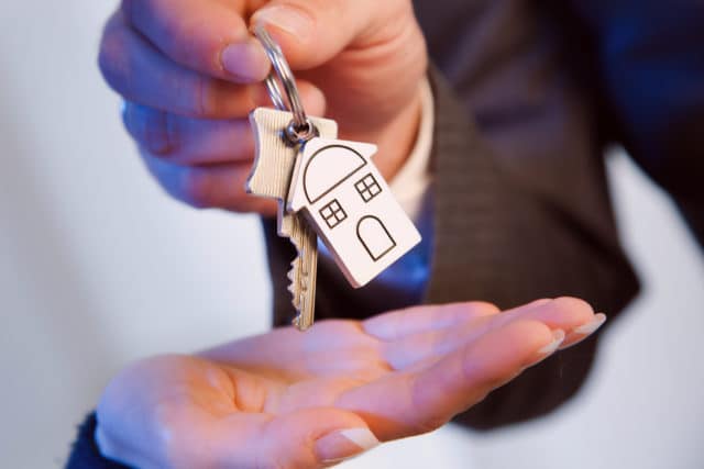 Eine Person übergibt einen Wohnungsschlüssel, Schriftzug: Mietnomaden