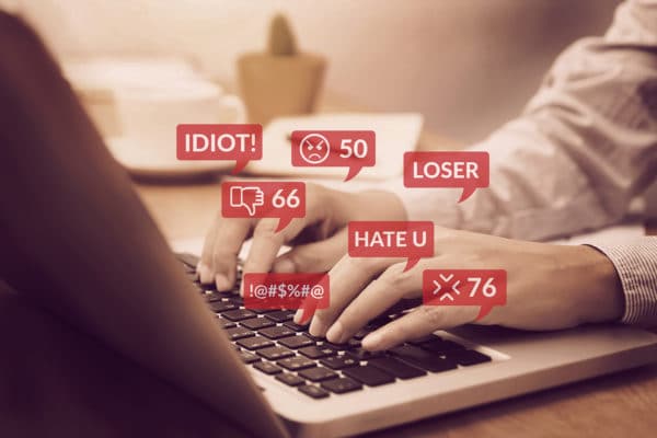 Person wird am PC mit Hasskommentaren gemobbt